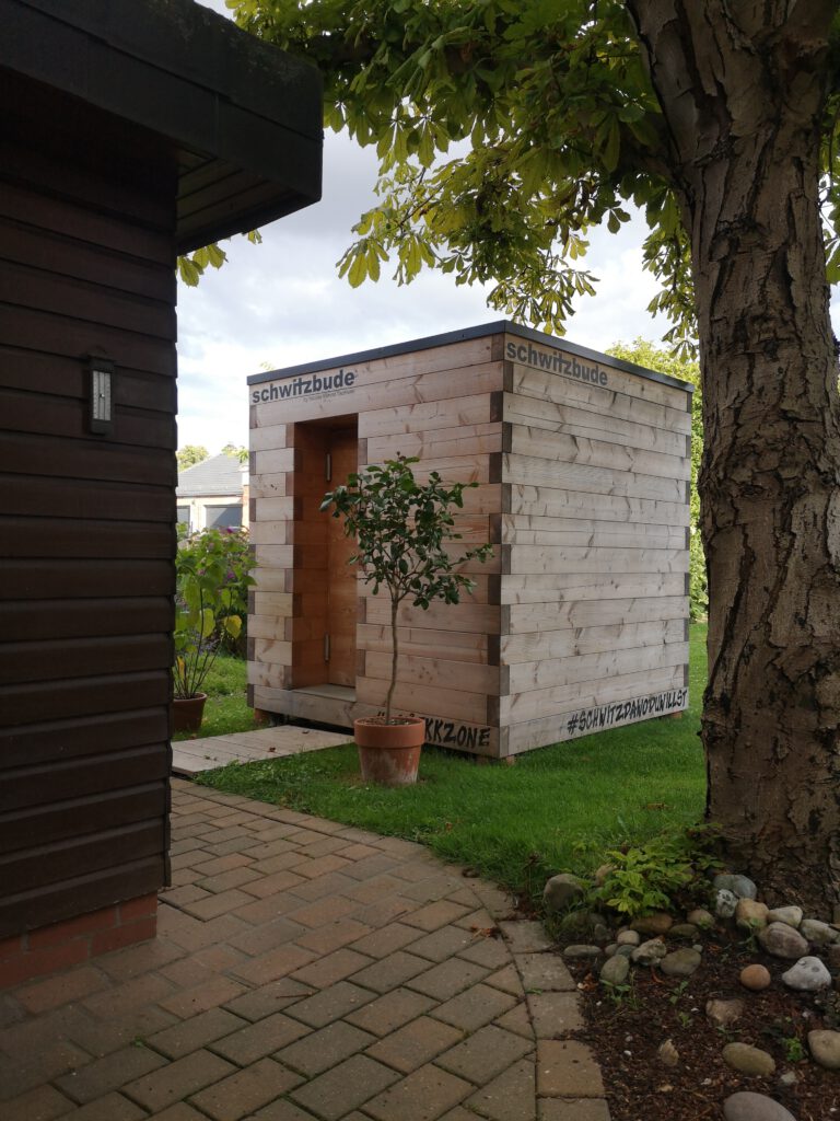 Holzauna mit Photovoltaikanlage im Garten